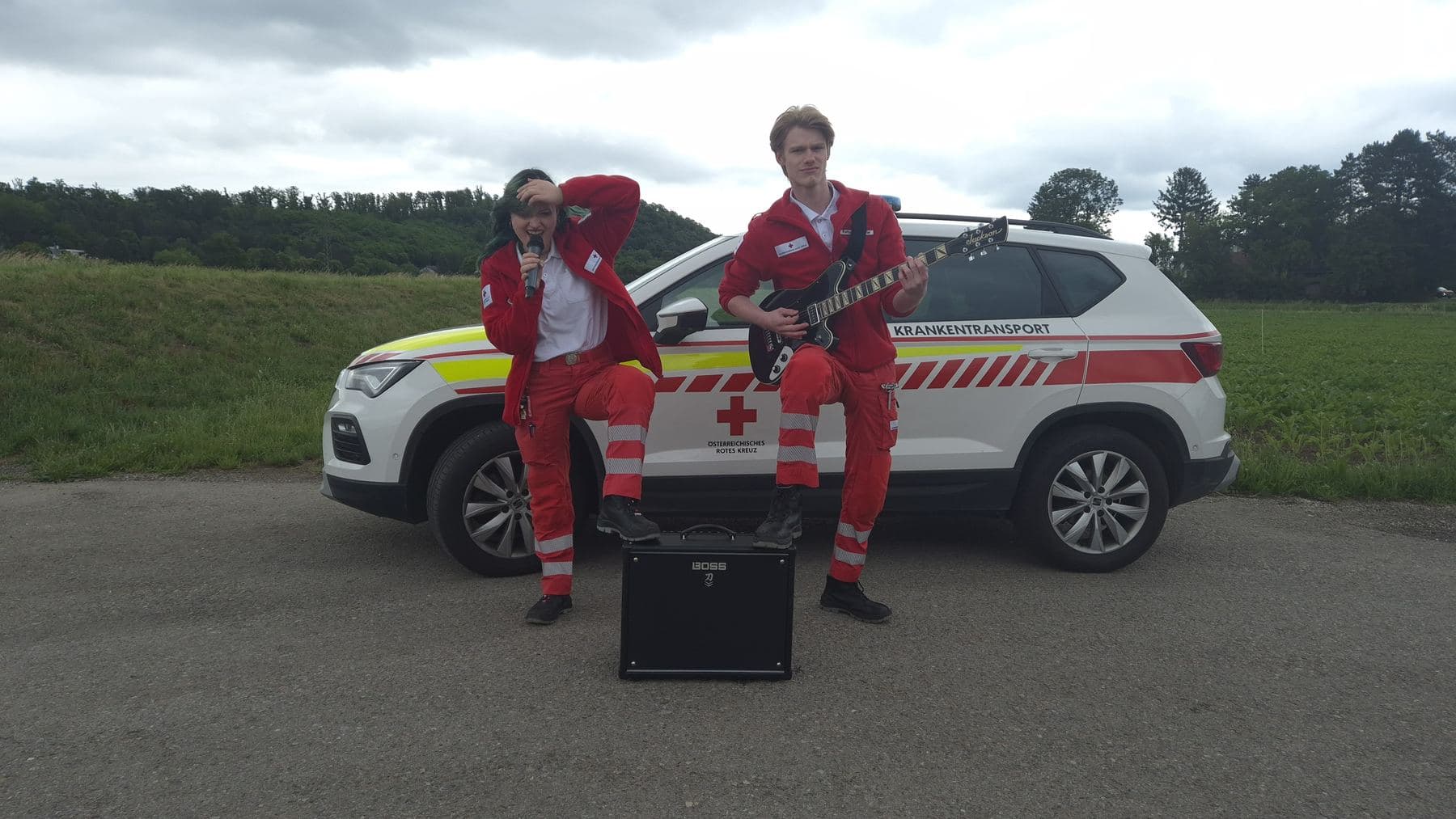 Pose mit Gitarre vor dem Fahrzeug